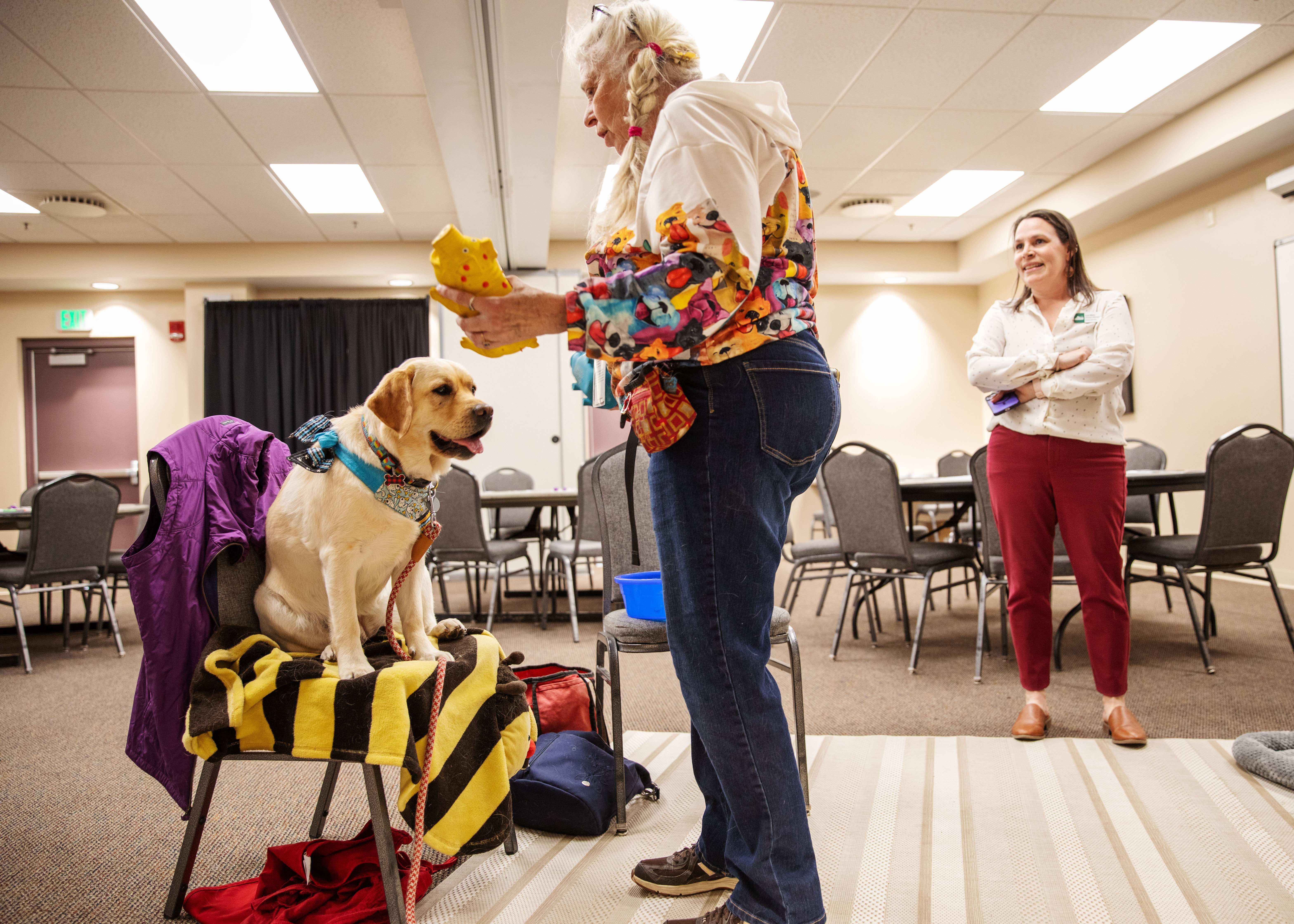 Image 7: Aging and Adult Services Division Manager, Lori Metz, watches a therapy dog do tricks.
