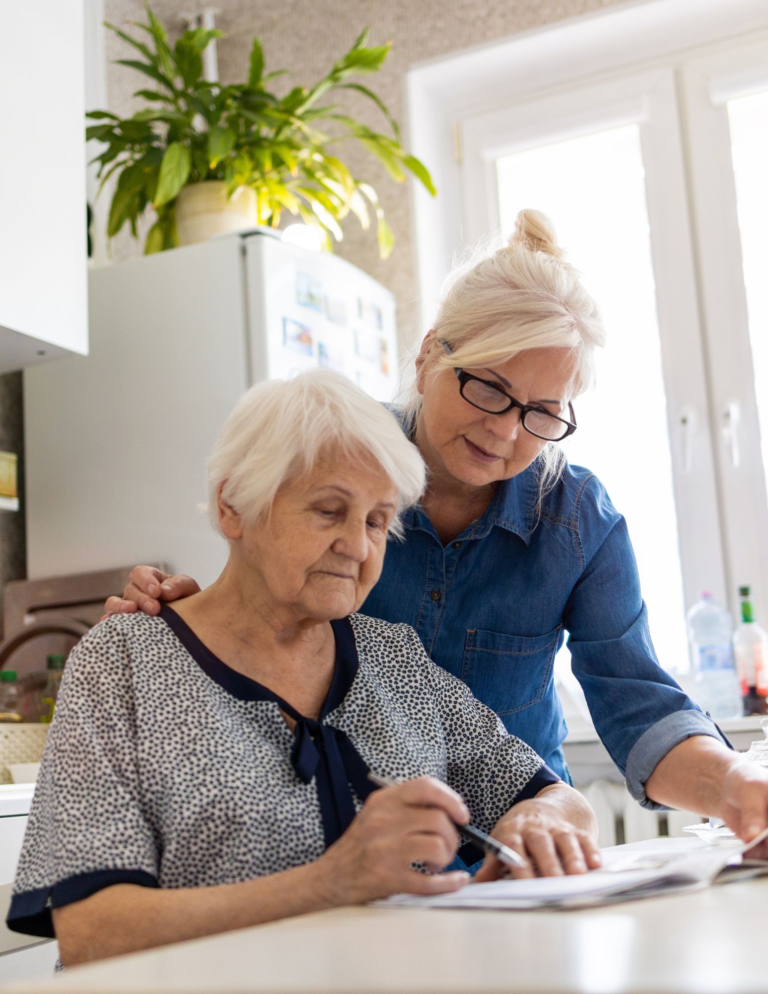 Two people look over paperwork in the kitchen