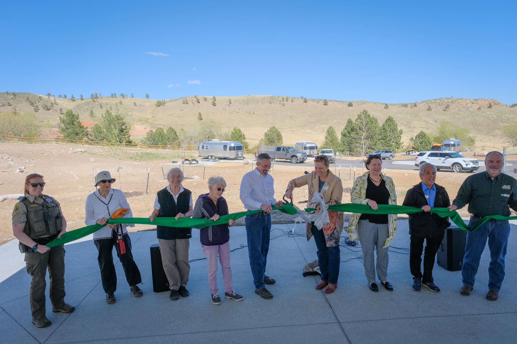 Image 2: Officials gather to cut the ribbon on the grand opening of Sky View Campground at Carter Lake. (Rod Cerkoney)