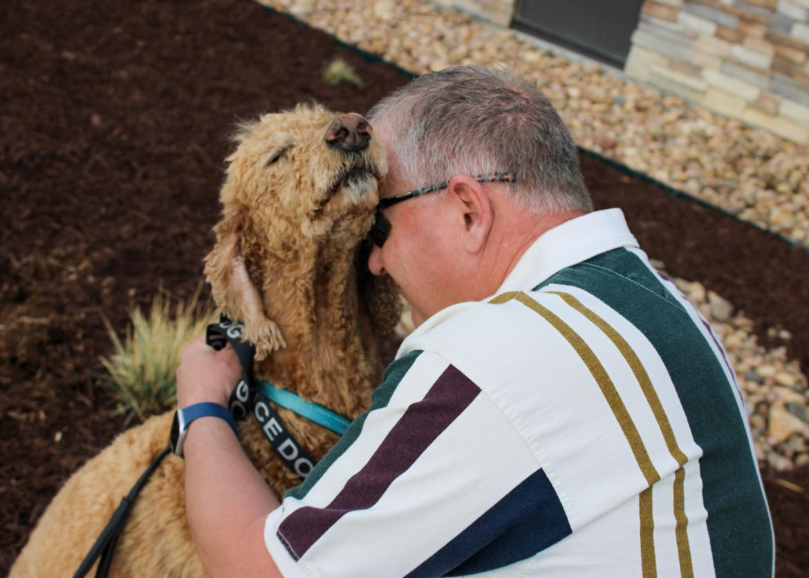 Steffen Essen, 51, of Loveland, poses with his service dog Remi in front of the Acute Care facility at Longview campus, between the cities of Loveland and Fort Collins.