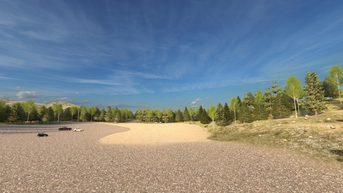 Reclaimed site showing gravel parking area, with pine trees surrounding it and blue sky above.
