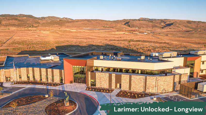 Aerial view of Larimer County Behavioral Health Services at Longview Campus, featuring a modern stone-and-glass building surrounded by open Colorado landscape and rolling foothills. A green banner along the bottom reads “Larimer: Unlocked – Longview.”