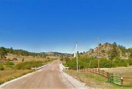 Dale Creek Bridge over County Road 45E, set against a backdrop of mountains under a clear blue sky