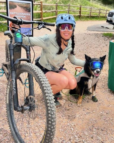 A woman with her mountain bike and small dog