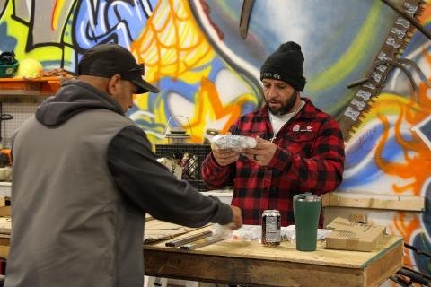 Two men build furniture at Harvest Farm in Wellington, Colorado