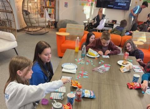 Youth sit at a table and do activities in the Teen Activity Center 212 in Larimer County