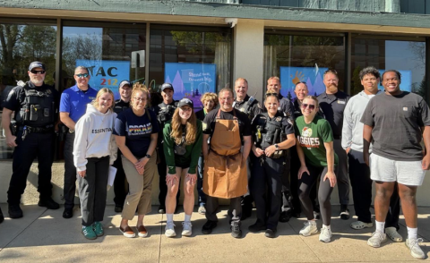 A group of adults and teens pose for a photo outside the Teen Activity Center 212 in Larimer County.