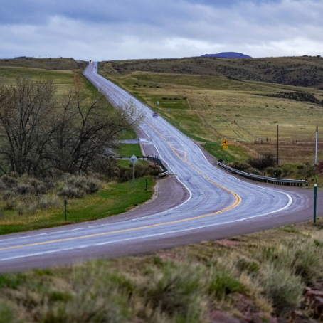 Highway 287 winding through rolling green hills.