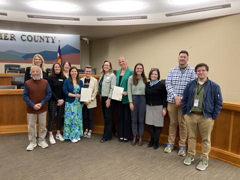 A group of Larimer County leaders, staff, and community partners pose for a photo for 2026 Mental Health Awareness Month 
