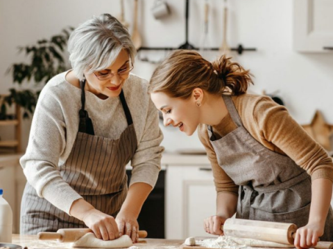 A grandmother bakes with her granddaughter