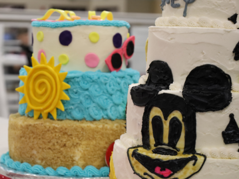 Two decorated cakes - one with a sun and the other with a cartoon mouse