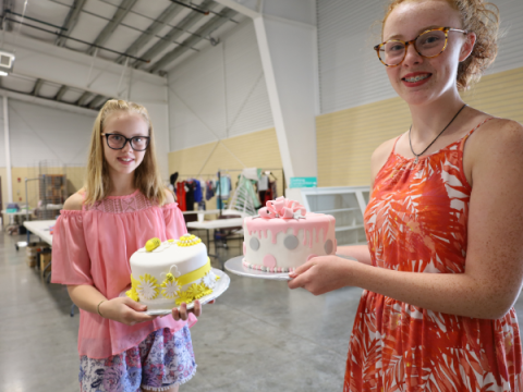 Two members of Larimer County 4-H show off their decorated cakes