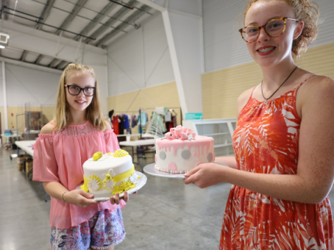 Dois membros do Larimer County 4-H exibem seus bolos decorados