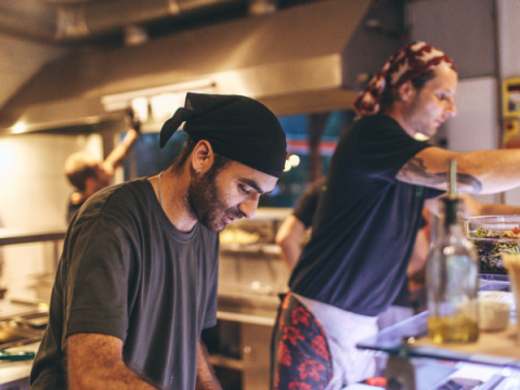 Two employees prepare food in a restaurant. 
