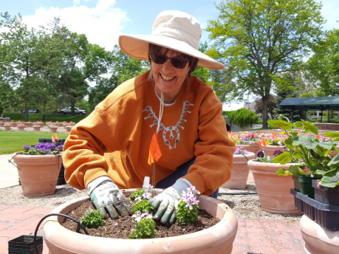 Een Master Gardener plant iets in een hele grote plantenbak