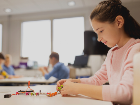 A pre-teen works on a demonstration circuit