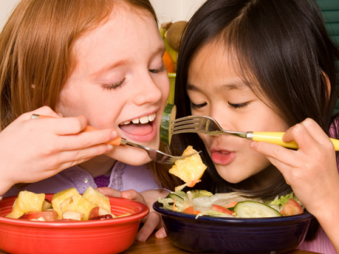 Dos niños disfrutan de un plato de comida.