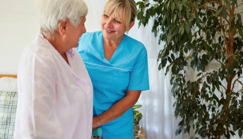 يقوم أخصائي الصحة المنزلية بمساعدة شخص بالغ كبير السن