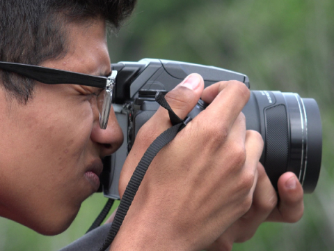 Un adolescente usa una cámara SLR para tomar una foto