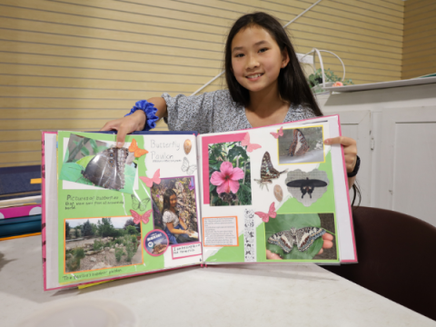 A 4-H member shows off her scrapbooked pages.