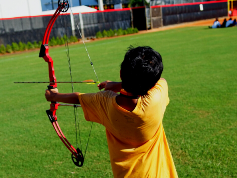 A teenager uses a bow and arrow