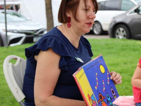 La commissaire du comté de Larimer, Kristin Stephens, lisant un livre pour enfants au marché des fermiers du comté de Larimer