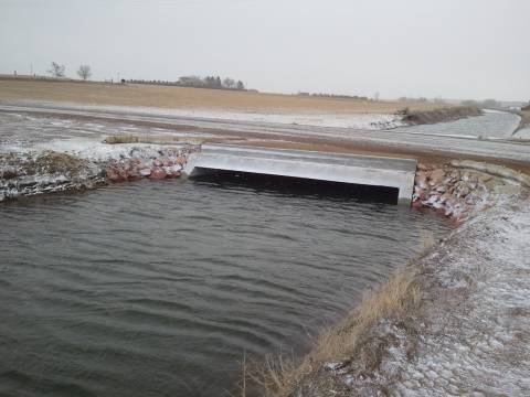 An irrigation ditch flowing through a concrete box culvert.