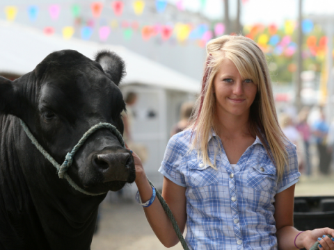 Uma adolescente mostra seu animal de mercado na feira