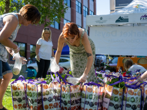Volunteers pack produce bags Volunteers pack produce bags