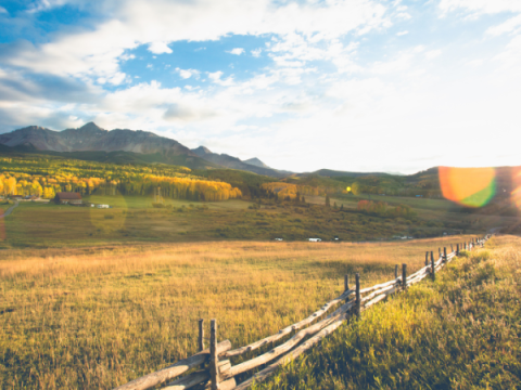 An open field with mountains in the background An open field with mountains in the background