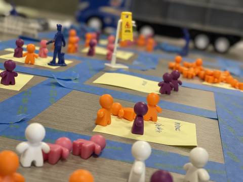 Close up of match-box cars and plastic people on map. 