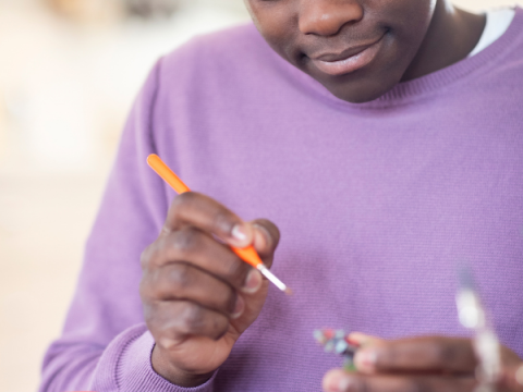 Un adolescente pinta una artesanía.