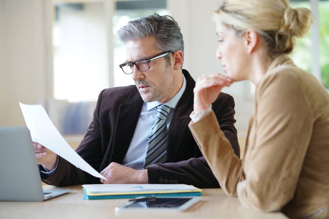 People reviewing a document together in an office.